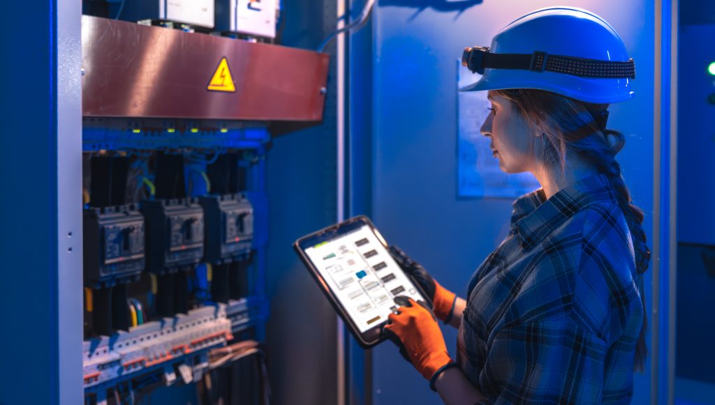 woman engineer checks electrical panel using digital schematic technical inspection